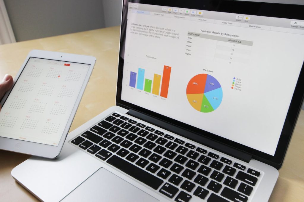 Laptop screen displaying pie chart, graph, and calendar tab for accounting outsourcing services.